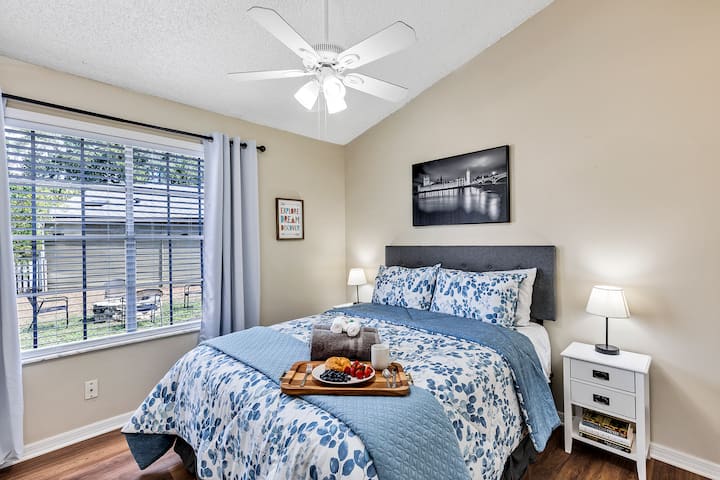 Dormitorio 3: cama tamaño queen con cabecera, ropa de cama cómoda, mesitas de noche blancas a juego, ventilador de techo, televisor Roku de 43pulgadas en la pared opuesta (no en la foto) y amplio armario.