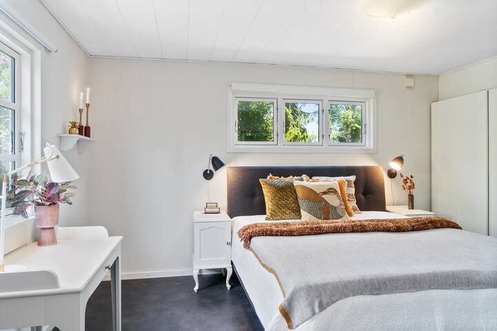 Grande chambre avec mur de placard et espace bureau.