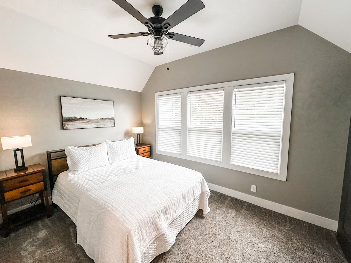 Chumba hiki cha kulala kimewekwa kwenye ghorofa ya pili, kina kitanda cha ukubwa wa malkia, sehemu ya kabati ya ukarimu, meza mbili kando ya kitanda zilizo na bandari za kuchaji na kabati kubwa la kujipambia, kuhakikisha starehe na urahisi wako wakati wote wa ukaaji wako.