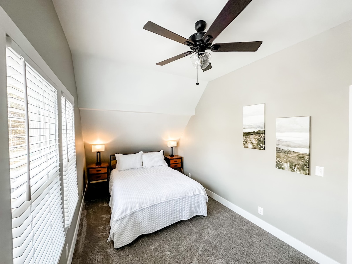 Iko kwenye ghorofa ya pili, chumba chetu kikuu cha kulala chenye nafasi kubwa kinatoa starehe na utendaji zaidi. Chumba hiki kina kitanda cha ukubwa wa malkia, sehemu kubwa ya kabati, meza mbili kando ya kitanda zilizo na bandari za kuchaji, kabati kubwa la kujipambia na dawati la ziada.