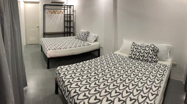 Perfect for families and groups of up to 9 individuals, our 2-bedroom home is designed for comfort and convenience. Here's our ground-floor bedroom, equipped with two plush queen-sized beds. 
