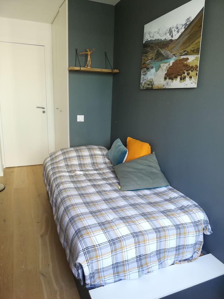 La habitación larga: una cama individual, escritorio, armario