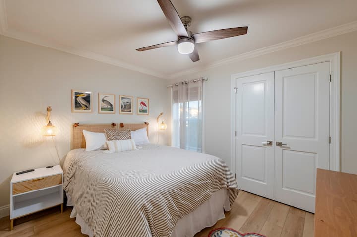 Relax in this cozy bedroom with a plush queen bed, soft lighting, and stylish decor for a restful stay!