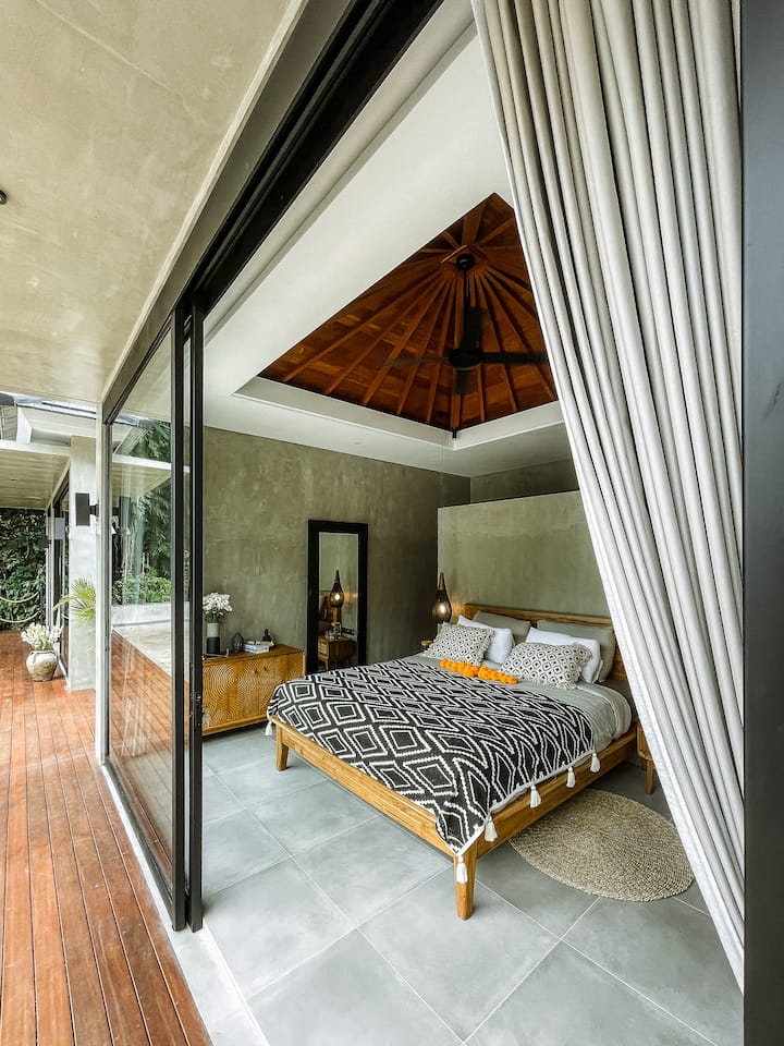 Chumba cha kulala chenye starehe cha 2 kilicho na dari zilizopambwa na milango inayoteleza kuelekea kwenye mazingira ya asili.