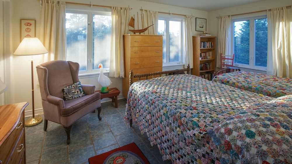 ทำด้วยมือใน Nova Scotia yoyo quilts บนเตียงคู่สไตล์วินเทจเหล่านี้ห้องนี้มีตู้เสื้อผ้าแบบวอล์คอินคุณเห็น Gladys the Goose ไหม? ห้องนอนนี้หันหน้าไปทางทิศตะวันตก - เงาที่สวยงามเมื่อพระอาทิตย์ตกดิน  