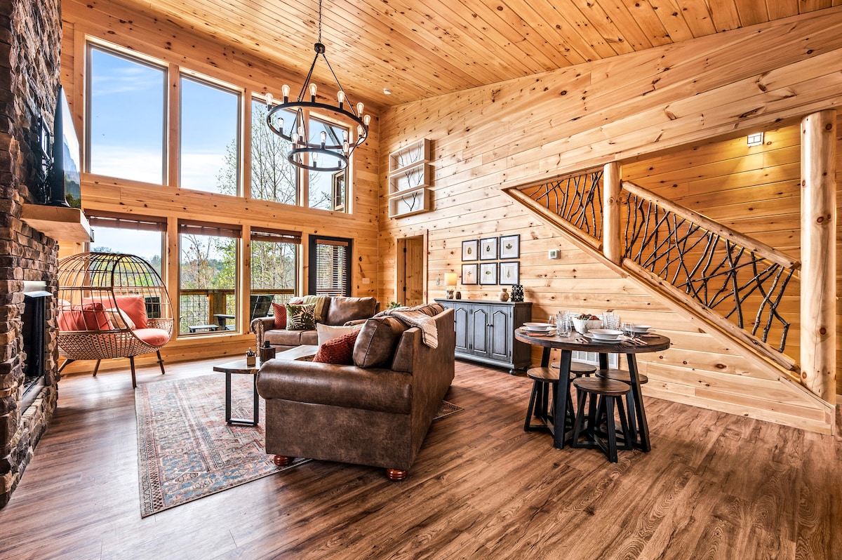 The lofty great room boasts beautiful floor to ceiling windows overlooking the amazing mountain view! The custom handcrafted twig stair rail brings the beauty of the surrounding woods into the comfort of this beautiful cabin.