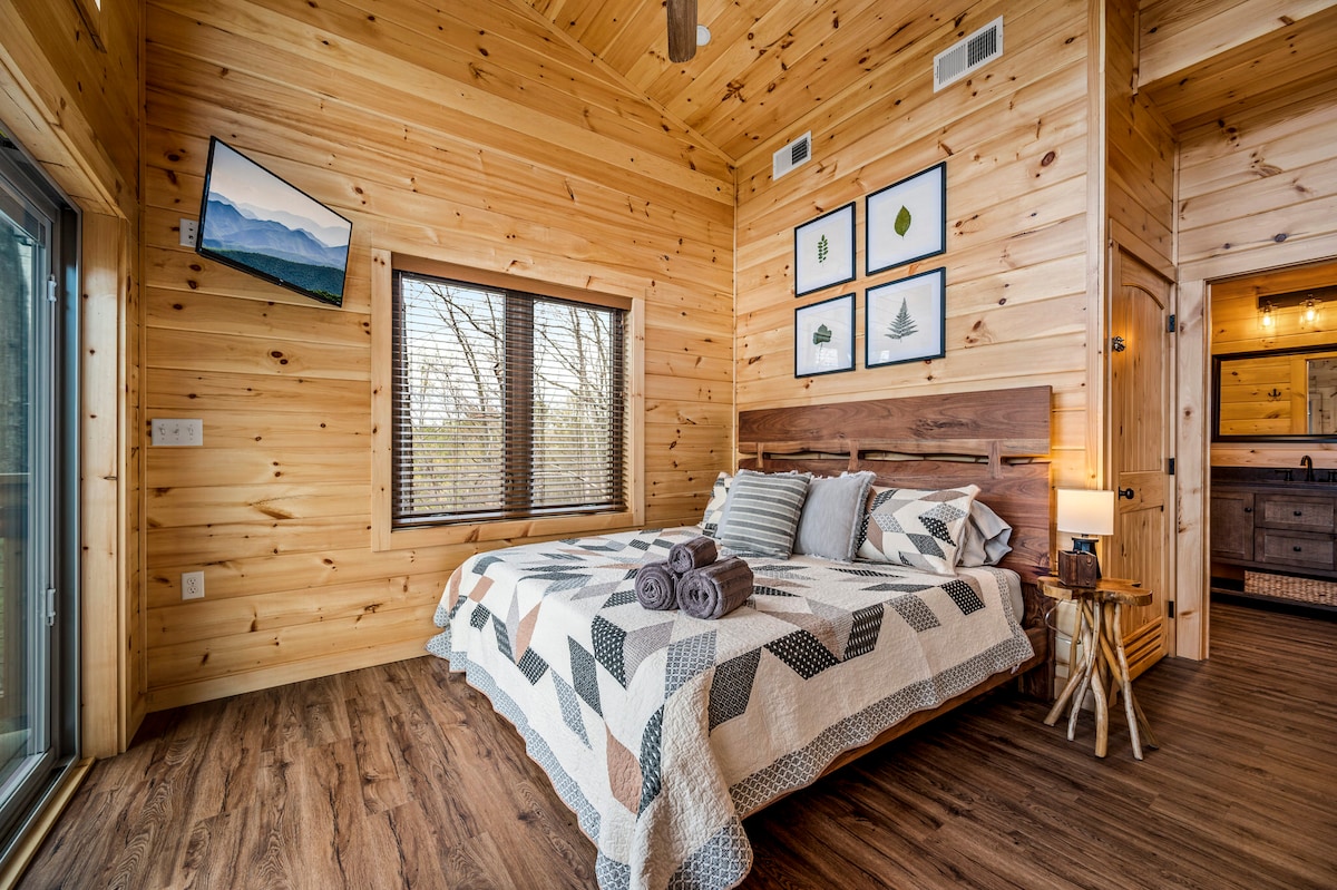 The luxurious king bedroom (upstairs) has lofted ceilings, an ensuite bathroom, and a closet in the bathroom for clothing storage. Walk out onto a private upper deck to enjoy the mountain view!