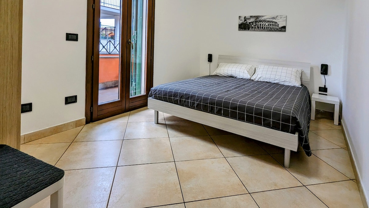 Spálňa s manželskou posteľou a lampičkou na čítanie.