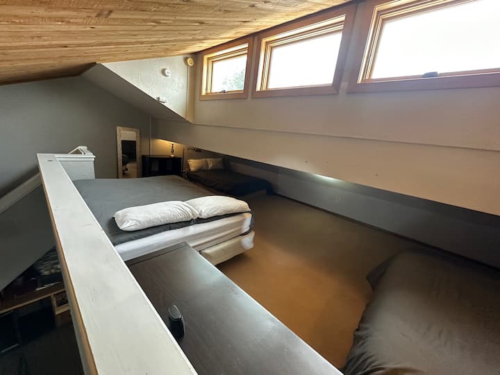 Roshani yenye vitanda 3. Kitanda kimoja kiko chini ya paa la mteremko. Roshani inafunguka kwenye eneo la sebule. 