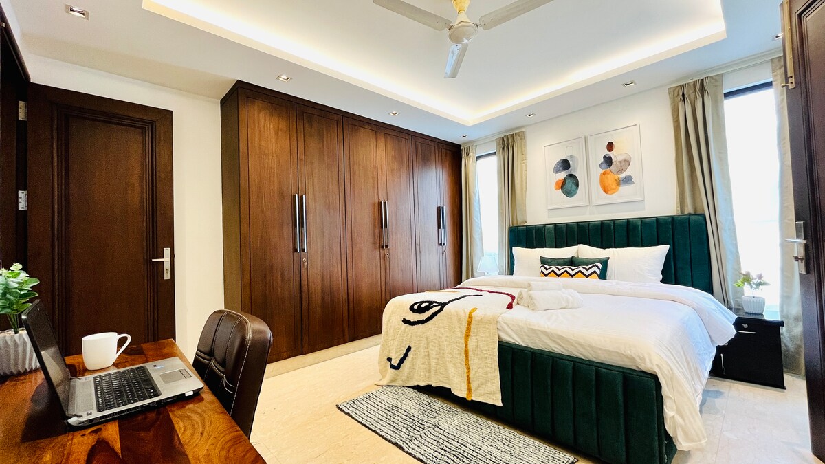 سرير مصمم مع مرتبة متميزة وخزانة ملابس واسعة وتلفزيون بشاشة مسطحة مع تاتا سكاي ومكتب عمل وحمام ملحق