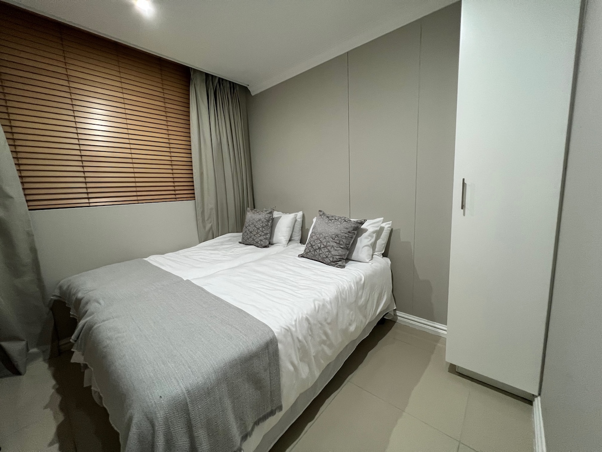 Chumba cha kulala chenye vitanda viwili vya mtu mmoja na kabati la mlango mmoja