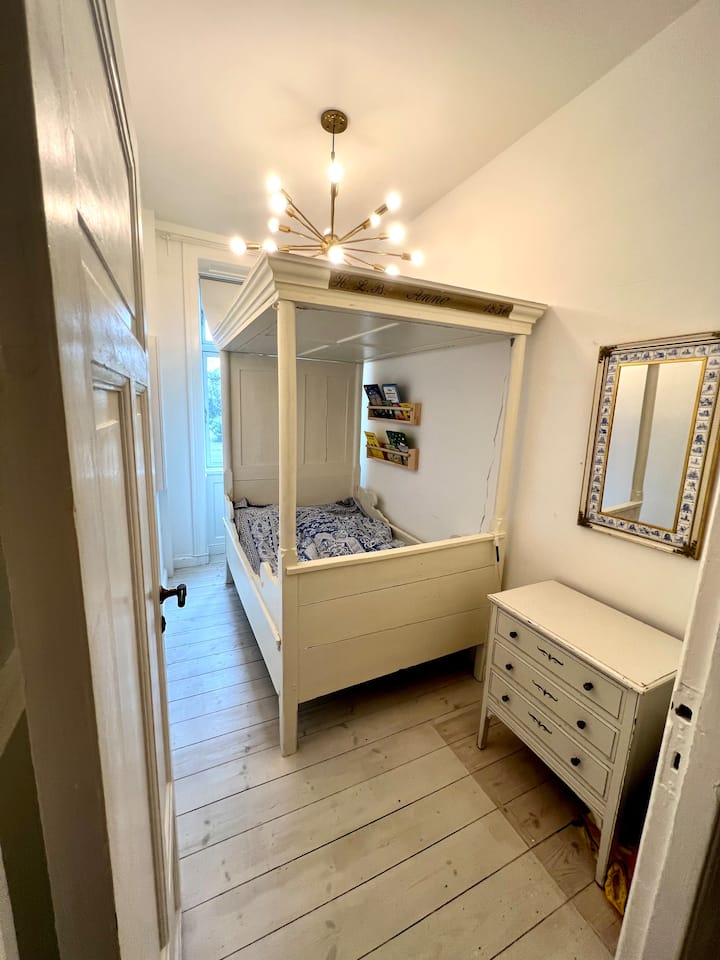 سرير أصلي جميل بأربعة أعمدة من عام 1836. يبلغ قياس السرير 185 × 110، لذلك تنام قريبًا قليلاً إذا كنتما بالغين. 