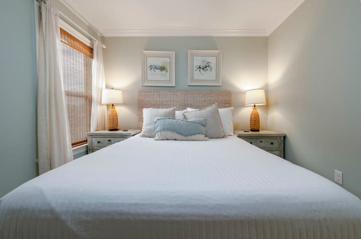 Relax in a cozy bedroom with a large bed, soft pillows, warm bedside lighting, and a peaceful atmosphere.
