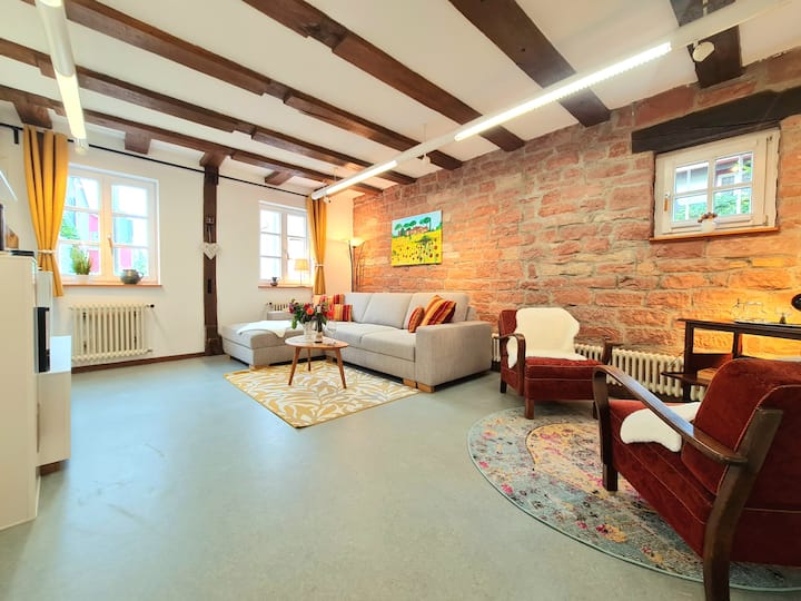 סלון גדול עם ספה נוחה מול קיר אבן חול ופינת ישיבה בסגנון וינטג'.
בסלון תמצאו גם מבחר משחקי לוח.