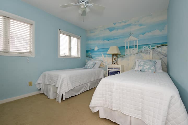 El dormitorio del piso principal tiene dos camas individuales extra largas y un vestidor, además de un baño completo con acceso al pasillo justo afuera de la puerta.