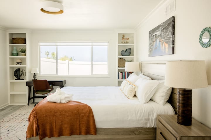 غرفة نوم رئيسية مزينة بذوق رفيع مع سرير كينج ومرتبة من الإسفنج ومساحة عمل لإمكانيات العمل عن بعد