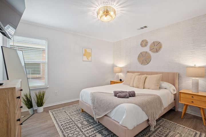 Dhomë gjumi në katin e poshtëm me një krevat dopio "queen", televizor inteligjent dhe pasqyrë me madhësi të plotë.