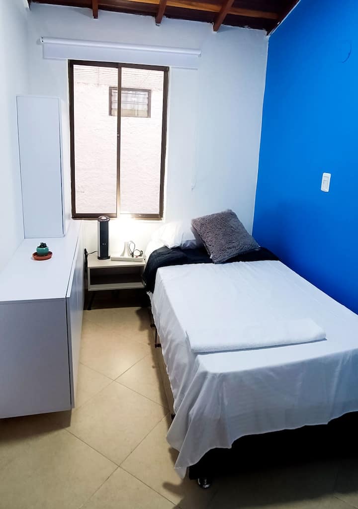 מקום לצוות אחד, כולל מגן בגדים, מאוורר, שולחן לילה עם מנורה 