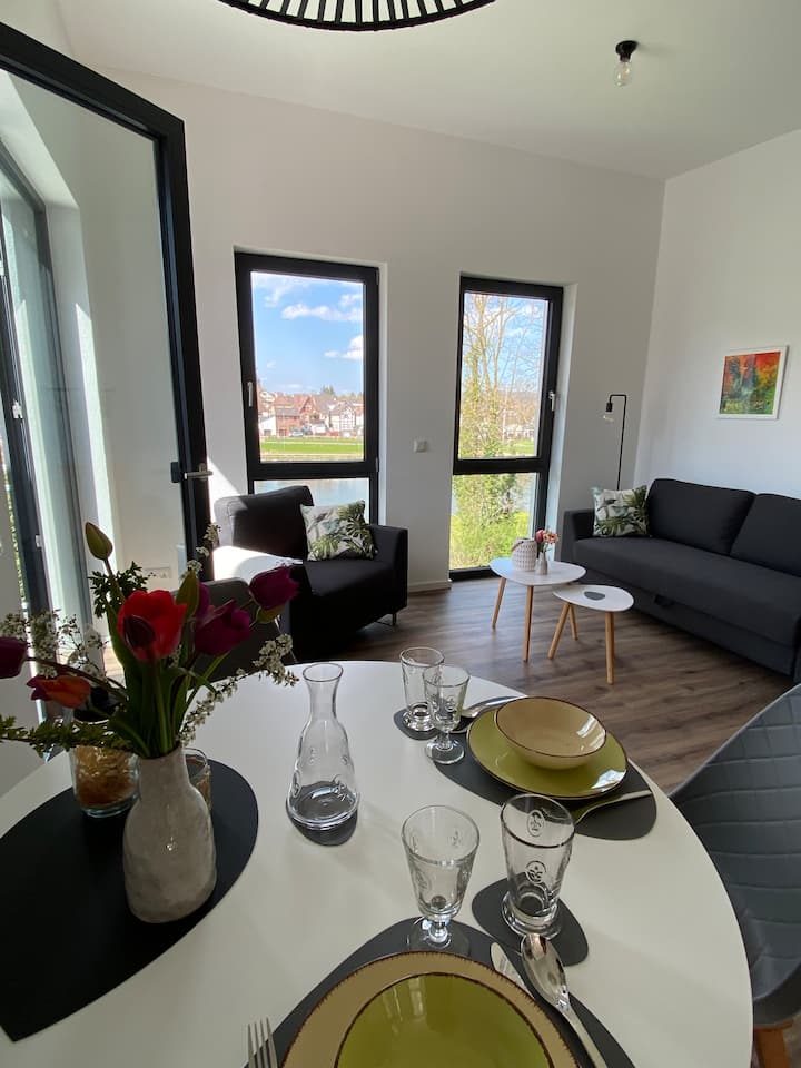 Vom runden Esstisch hat man einen schönen Blick durch die bodentiefen Fenster