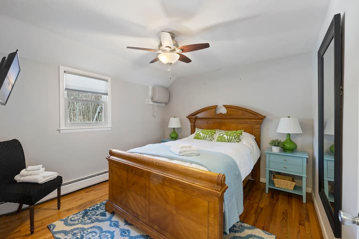 Chumba cha kulala chenye starehe katika nyumba iliyo katika misitu yenye utulivu ya Monroe. Chumba hicho kina kitanda kizuri, kiti maridadi na kioo kilichowekwa ukutani, na kuongeza mvuto wake. 