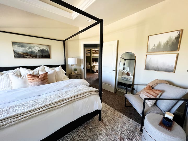 Primarna spavaća soba opremljena je ovim zadivljujućim krevetom s posterom, umjetničkim djelima po mjeri i televizorom ravnog ekrana. 