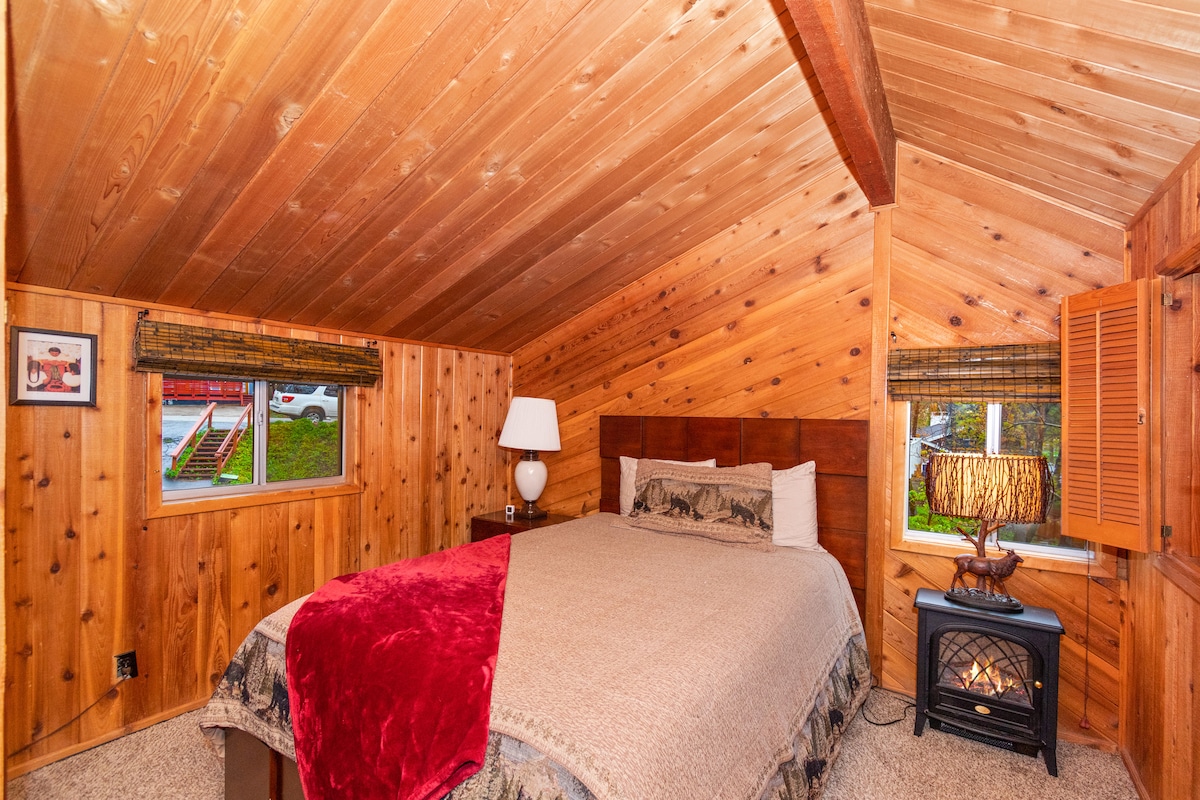 Habitación en el segundo piso con cama queen y calentador de chimenea sintética.