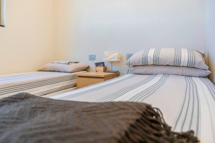 חדר השינה בקומה העליונה עם שתי מיטות יחיד.