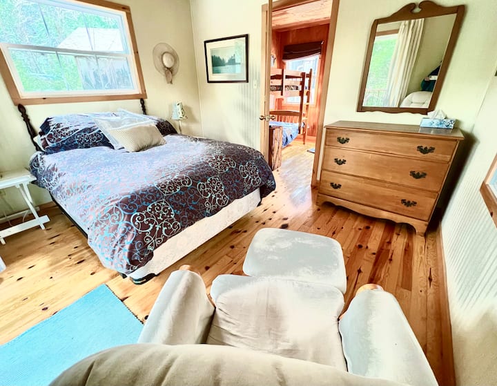 Bunkie Bedroom 2-ადგილიანი საწოლი ქვედა პლედითა და როკერით.  Თუ ბავშვებს მომდევნო ოთახში სძინავთ, ამ ოთახში შესვლა შეგიძლიათ გარე კიბით, პატიოს კარების მიღმა მდებარე ტერასიდან. 