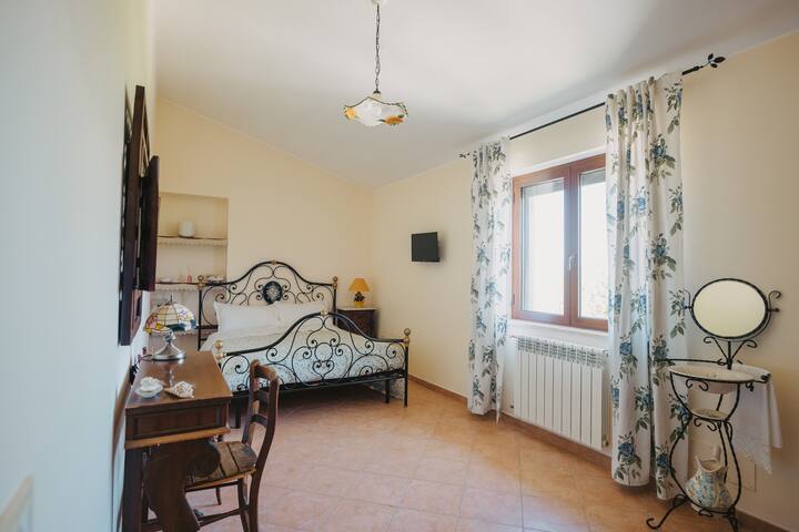 Second double bedroom on the upper floor with queen size bed, smart TV, full-height mirror and window overlooking the mountains and Mount Terminillo.