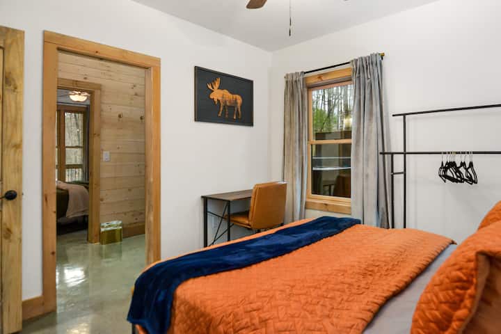 ห้องใต้ดินพร้อมเตียงควีนไซส์และโต๊ะคอมพิวเตอร์