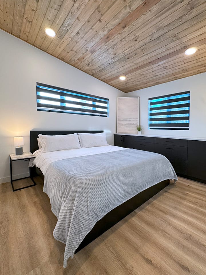 King bedroom suite with attached ensuite, television and storage.