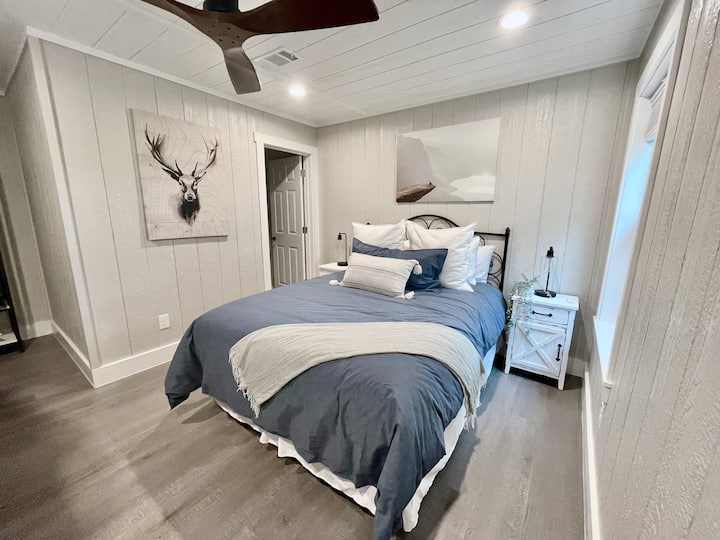 [Dhoma e gjumit #2] Përfshin një krevat dopio "Queen" dhe një krevat marinari. Banja ngjitur ndodhet në cepin e largët të fotografisë, pak përtej krevatit.