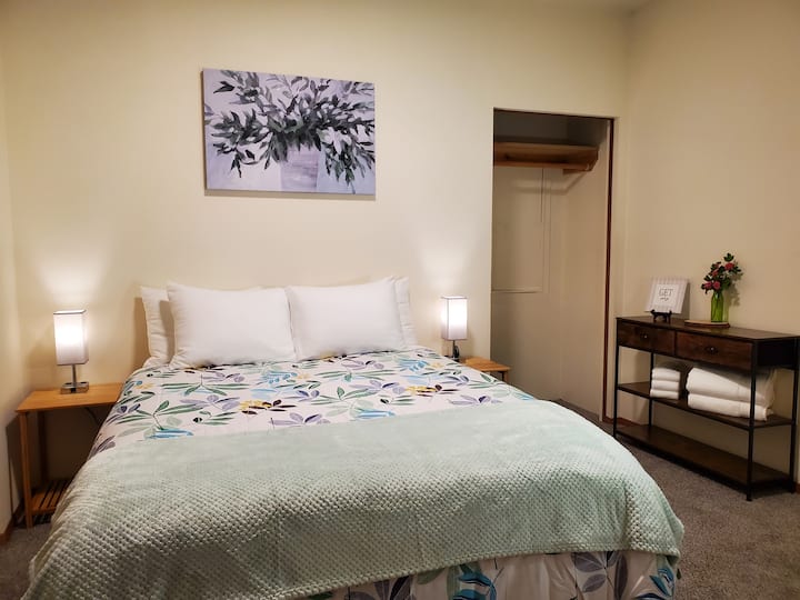 Dormitorio 1. Cama queen, puertos USB y enchufes eléctricos en las lámparas de noche.