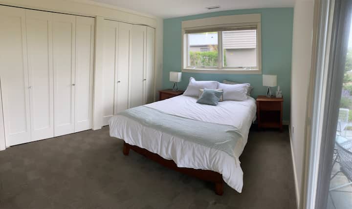 Habitación tamaño queen del segundo huésped en la suite familiar de la primera planta con vistas al mar, puerta corrediza de vidrio al patio