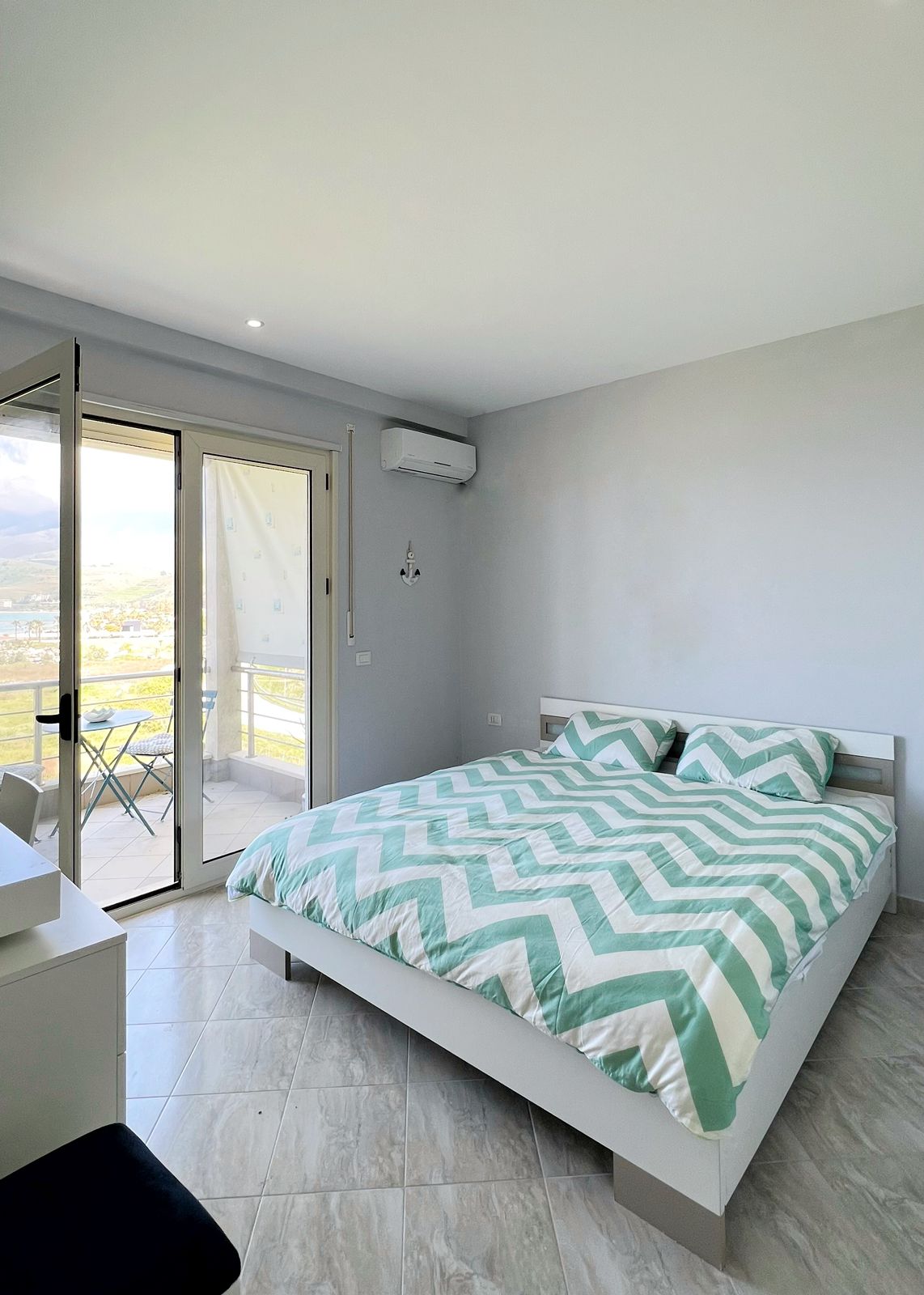 Schlafzimmer mit Kingsize-Bett und Zugang zum Balkon, mit Meerblick.