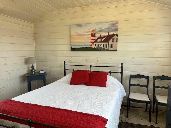 The West Quoddy bedroom has a queen size bed, blackout shades, bureau, and storage hooks.