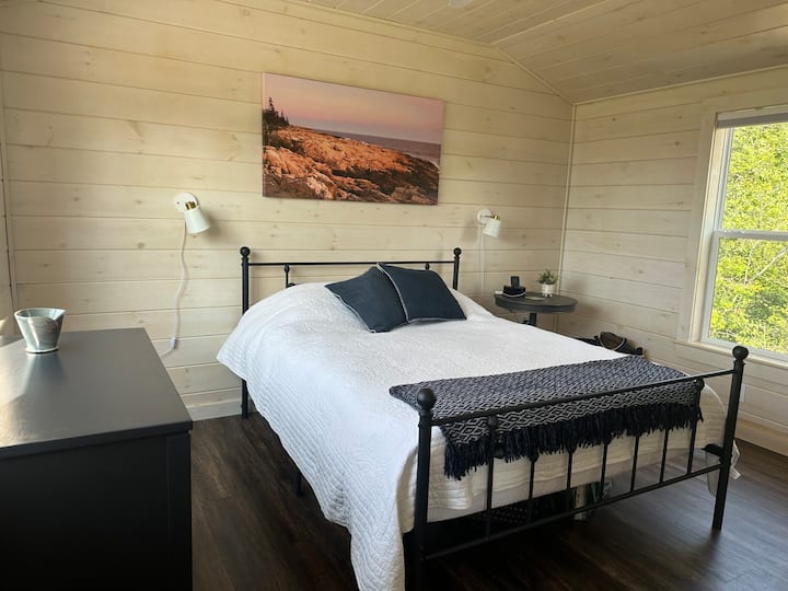 The Bold Coast bedroom has a queen bed, blackout shades, bureau, and closet.