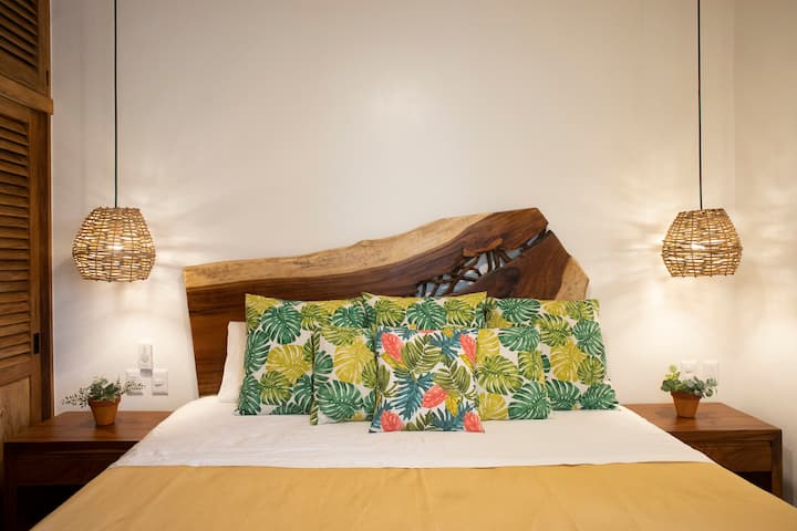 Chumba kikuu cha kulala kilicho na kitanda cha ukubwa wa kifalme, feni ya dari na kiyoyozi.