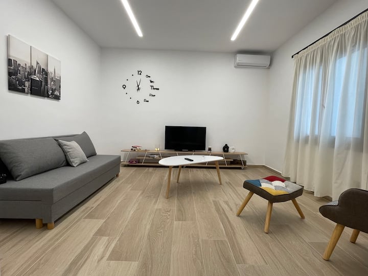 La sala de estar es una habitación espaciosa. El suelo es del color de la madera, lo que da una sensación de calor mientras las lámparas se atenúan para hacer el ambiente que deseas. Cuenta con un sillón con un reposapiés separado, un sofá cama y una televisión inteligente.