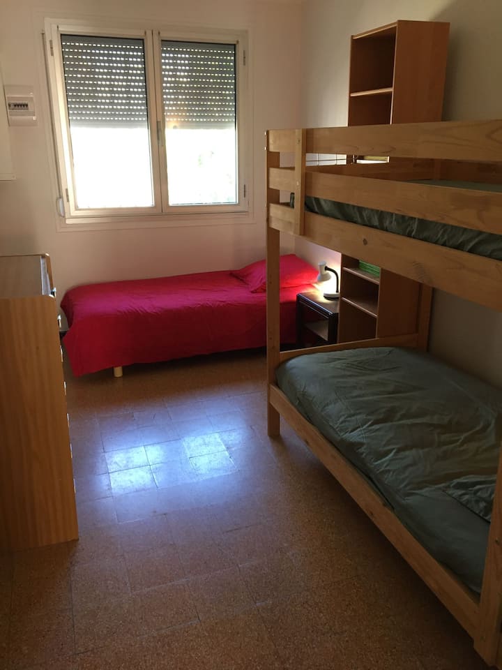 Camera da letto 2: letti a castello, letto singolo, ripiano con giochi da tavolo, cassettiera.
