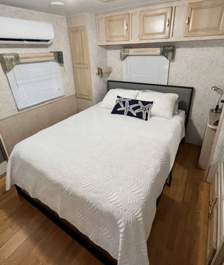 Დედოფლის ზომის საწოლი, რომელიც მდებარეობს უკანა საძინებელში