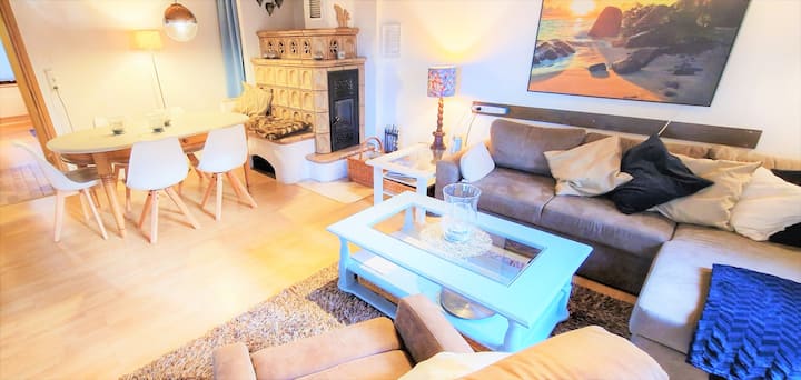 Útulný obývací a jedálenský priestor s krbom ako miesto rodinného stretnutia.
Pohovka môže byť za niekoľko minút premenená na posteľ.
(Bett 3: 1,20m x 2,00m)