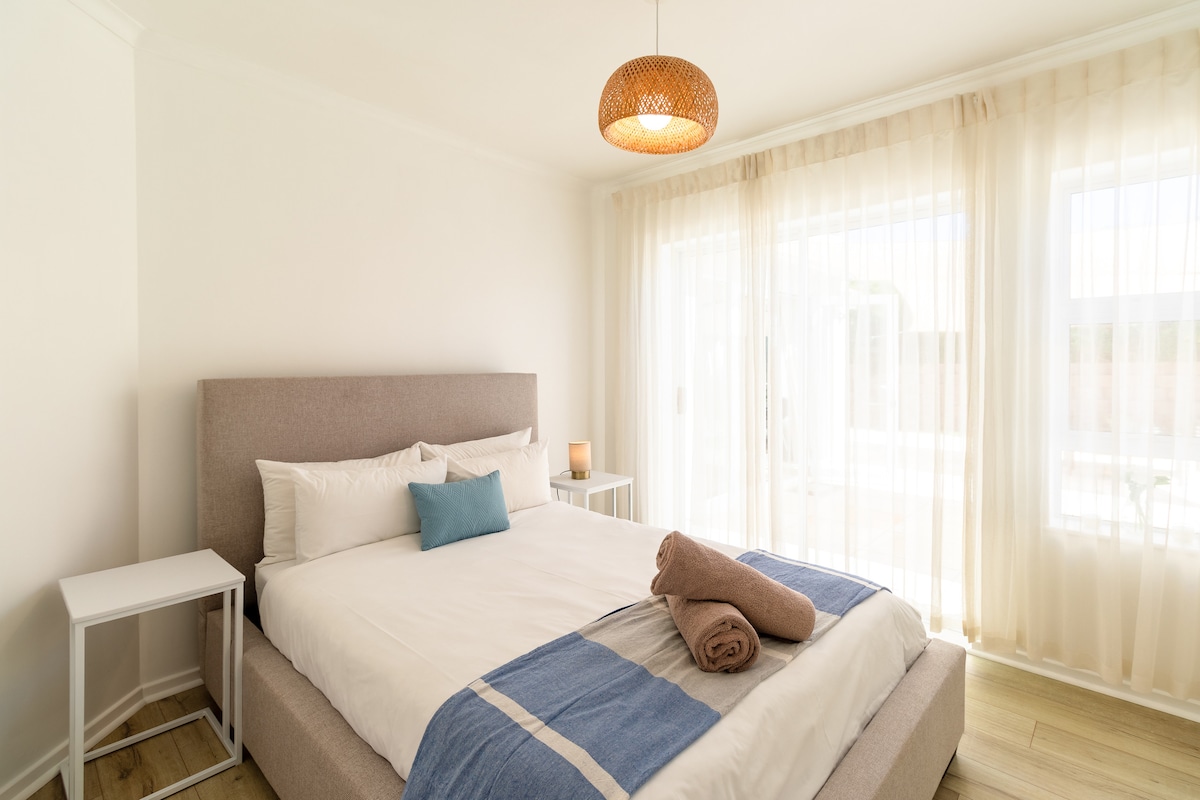 Втора спална соба со врати кои водат до просторот во дворот и базенот