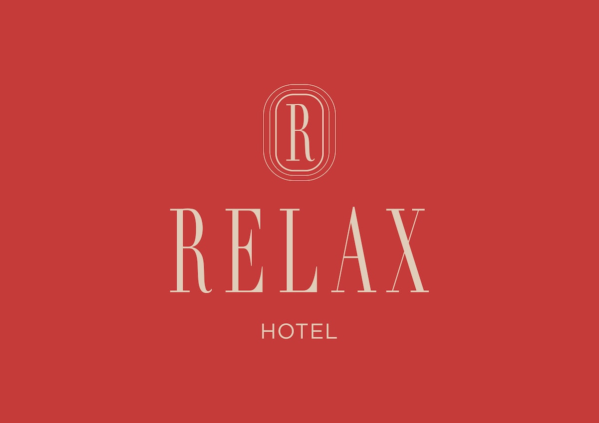 A bold logo design is displayed against a vibrant red background. The word 'RELAX' is prominently featured in large, elegant lettering, complemented by the word 'HOTEL' in a smaller font beneath. A circular emblem with the letter 'R' is positioned above the text.