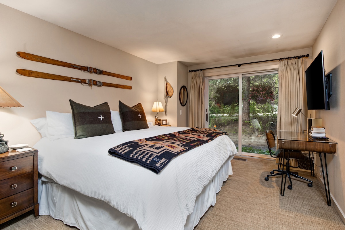 El segundo dormitorio king tiene puertas correderas de vidrio que conducen al patio lateral y tienen cortinas de ropa de cama opacas de diseño. 