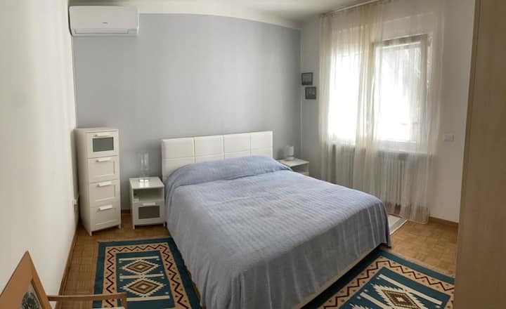 Chambre double avec grande armoire, tables de chevet et commode.