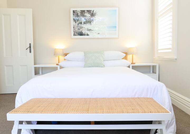 Chumba kikuu cha kulala cha ghorofa ya 2 kina kitanda aina ya queen,  roshani na chumba cha kulala. 