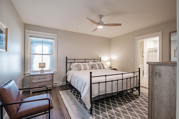 Dormitorio principal con silla cómoda.