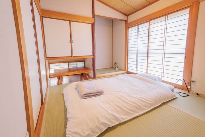 Слика од футон влечена во соба во јапонски стил на западната страна.Дрвеното биро може да се чува под висечкиот шкаф.