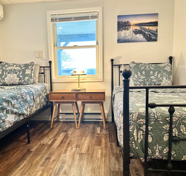 غرفة نوم في الطابق السفلي مع إطلالة على الفناء الخلفي والبحيرة